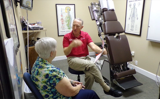 Clinician seated in an examination room discussing care with an older adult
