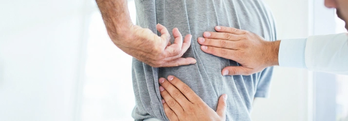 Healthcare provider examining a patient’s lower back