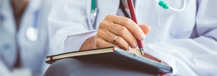 Close-up of a healthcare professional writing notes